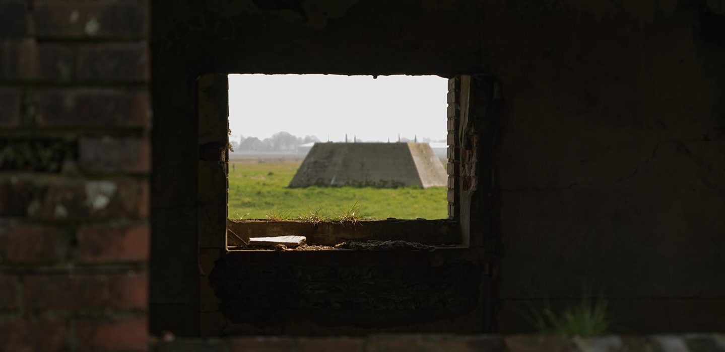 The old foundation of the radar seen through the window of a bunker.